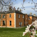 Clone House and gardens framed by spring blossom
