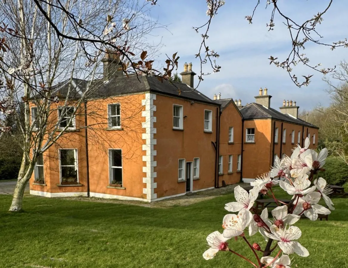 Clone House and gardens framed by spring blossom