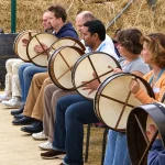Corporate group playing bodhráns during an Irish music workshop in Ireland