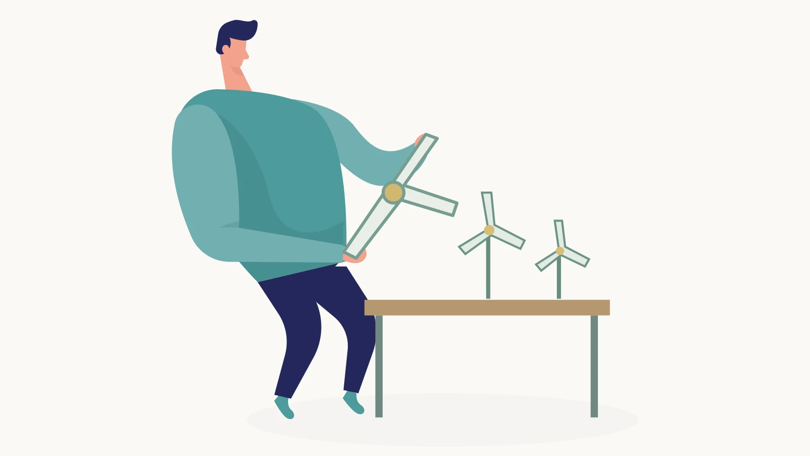 A participant assembles a wind-turbine rotor beside model turbines on a workshop table.